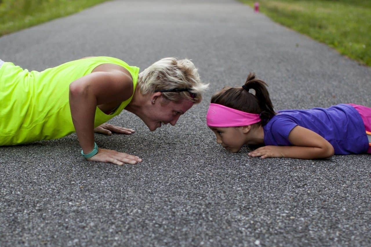 mother and daughter exercising on road