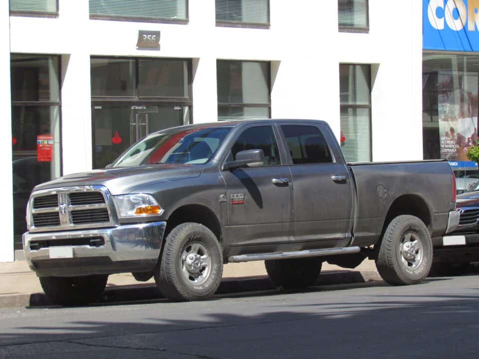 A focused man maneuvers a Ram 2500 truck with a heavy-duty trailer, displaying concentration and careful attention. Ram 2500 2