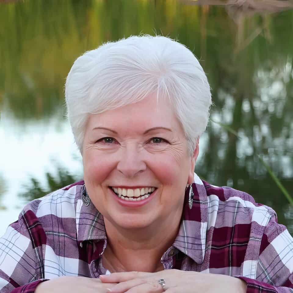 Funny elderly woman smiling outdoors near water, cheerful senior lady with white hair, photography for senior lifestyle, happiness and positive aging, natural outdoor portrait of mature woman.