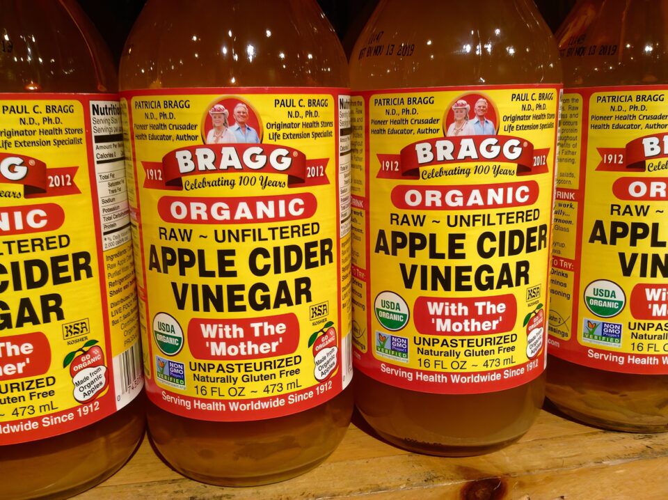 Organic apple cider vinegar bottles with unfiltered raw content, emphasizing health benefits and natural ingredients for wellness and detox.
