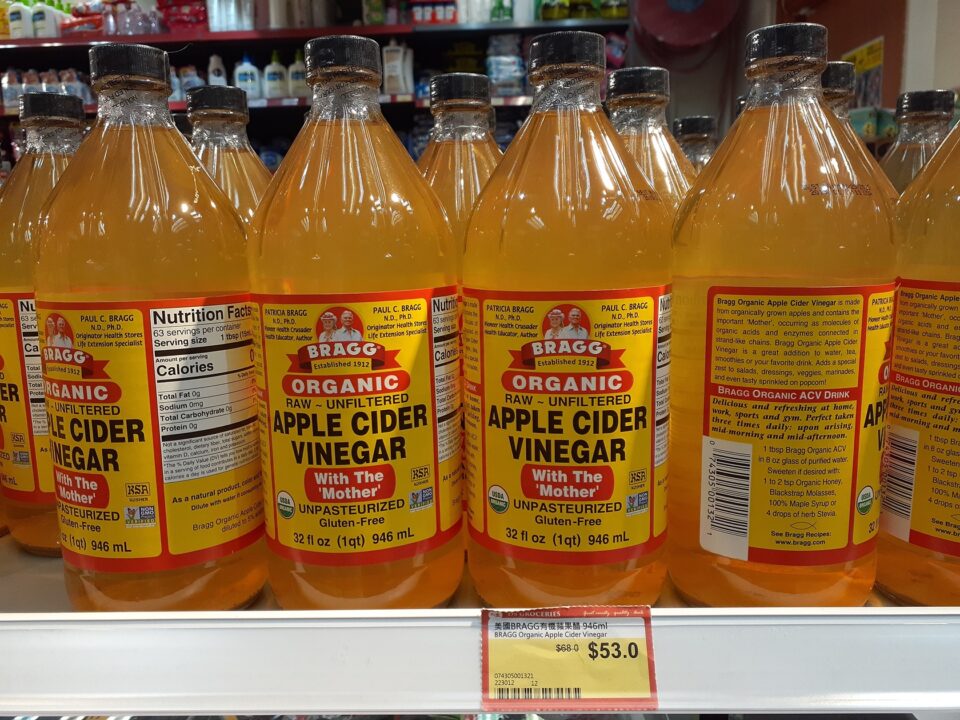 Bragg Organic Apple Cider Vinegar bottles on store shelf, highlighting health benefits and dietary uses, emphasizing organic, raw, unfiltered, gluten-free qualities.