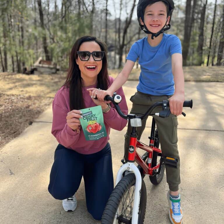 Cheerful woman and boy with biking gear outdoors.