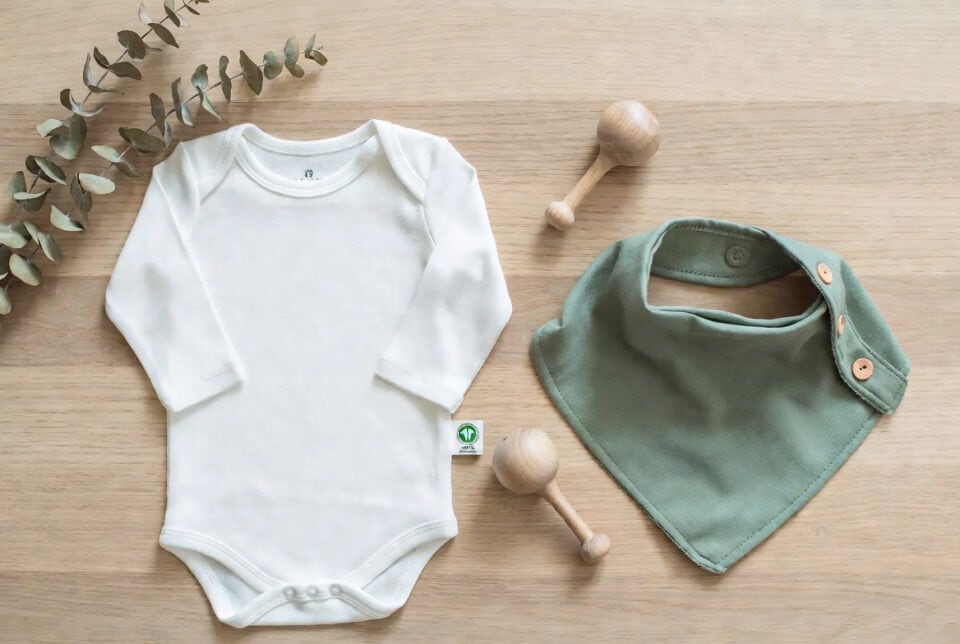 Organic baby onesie and bib for newborns, soft and sustainable clothing essentials for infants' comfort and everyday wear.