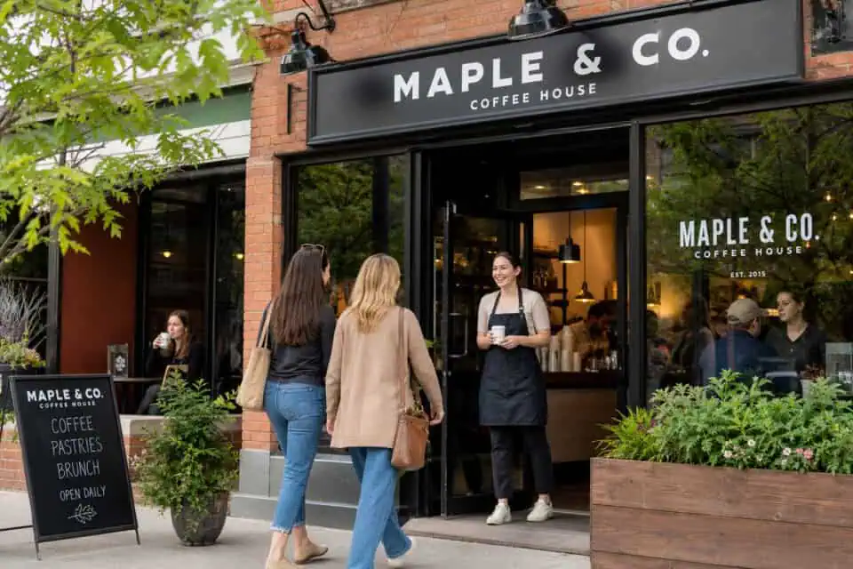 12 Types of Entrepreneurs: Mapping Your Path to Autonomy 9 Exterior view of Maple & Co. Coffee House with customers ordering and socializing outside on a lively street.