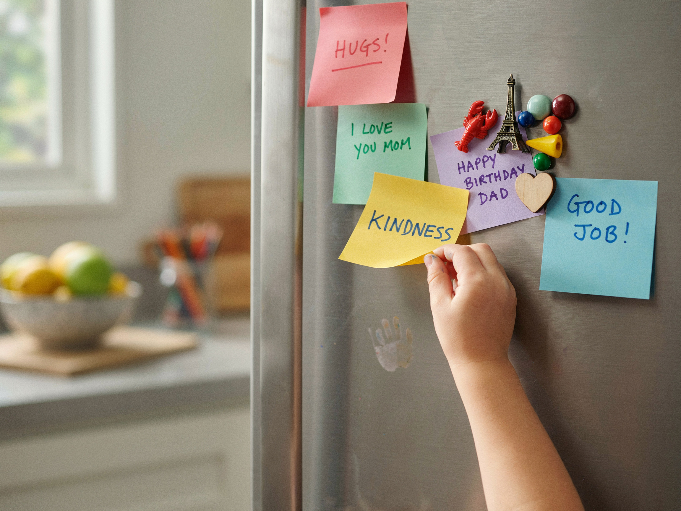What Is the Value of Family? A Practical Guide to Defining What Matters Most 6 Child placing a sticky note with a value word on a fridge, making family values visible.