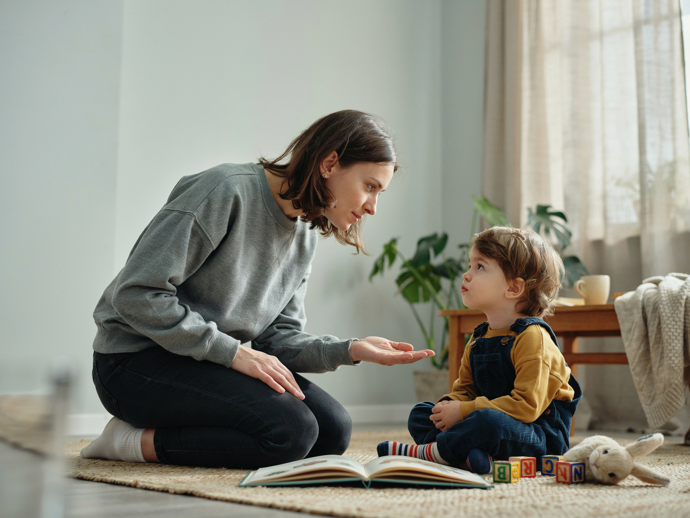 10 Family Values That Actually Stick: A Curated List With Age-Specific Tips 2 Parent apologizing to child on living room floor, modeling honesty and repair after a mistake.