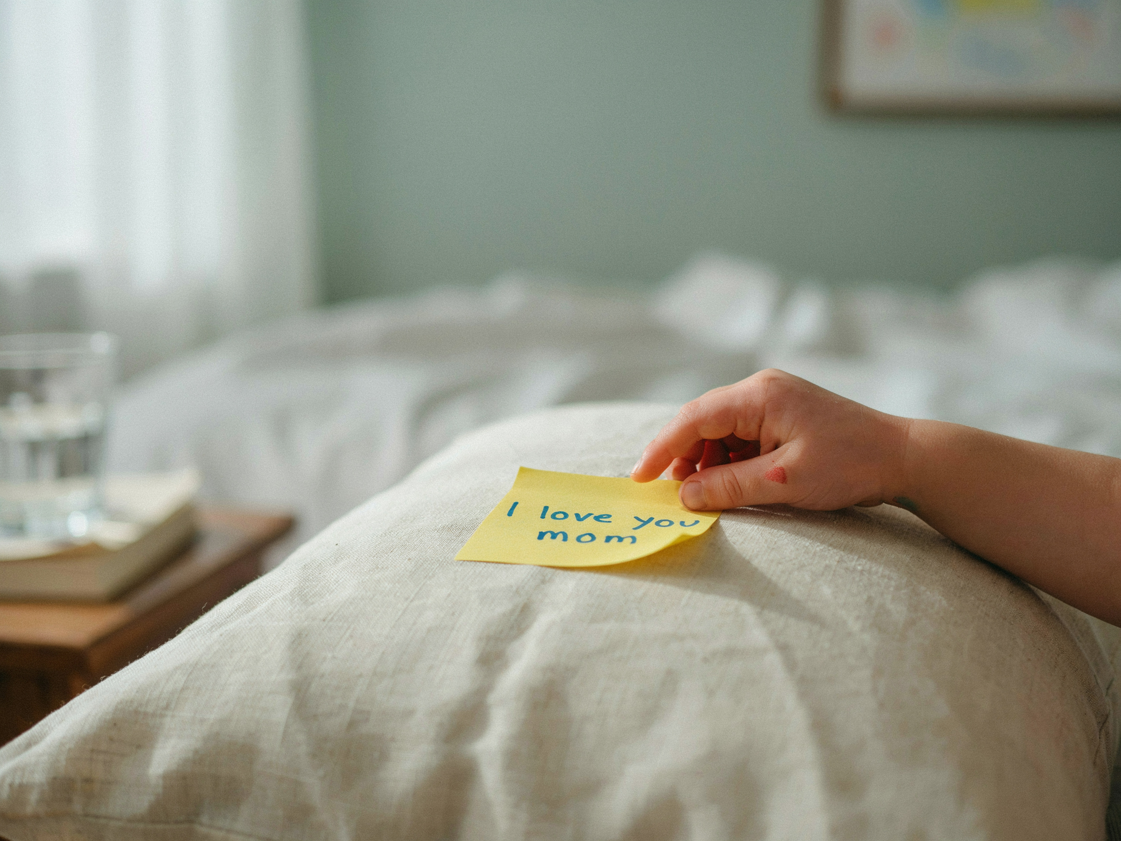 25 Family Values Examples: Specific Behaviors and SMART Goals You Can Start Tonight 2 Child's hand placing a sticky note on a pillow for a love note family value activity