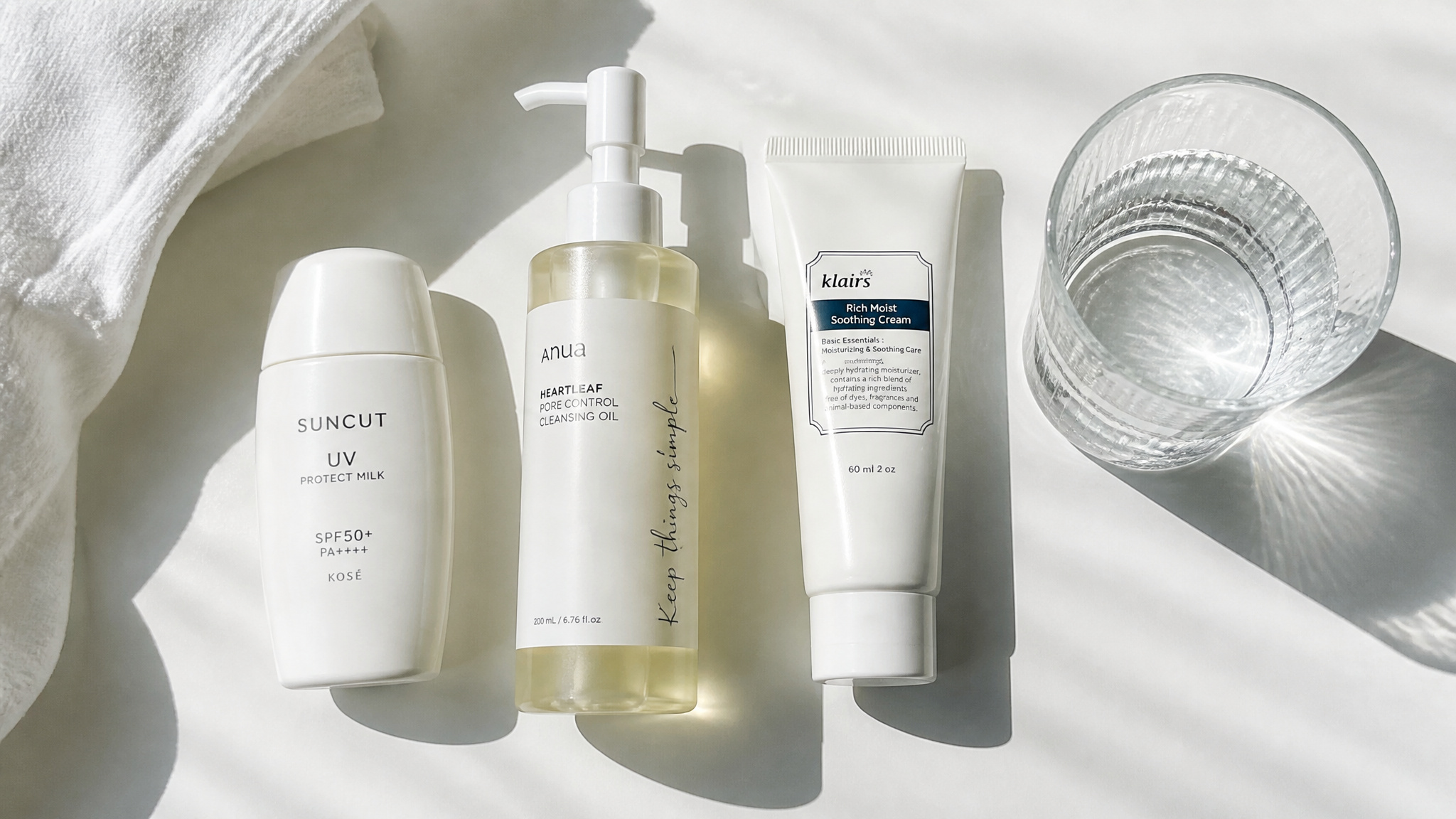 Minimal skincare routine with sunscreen, cleanser, moisturizer, and water representing the boring but effective anti-aging habits.