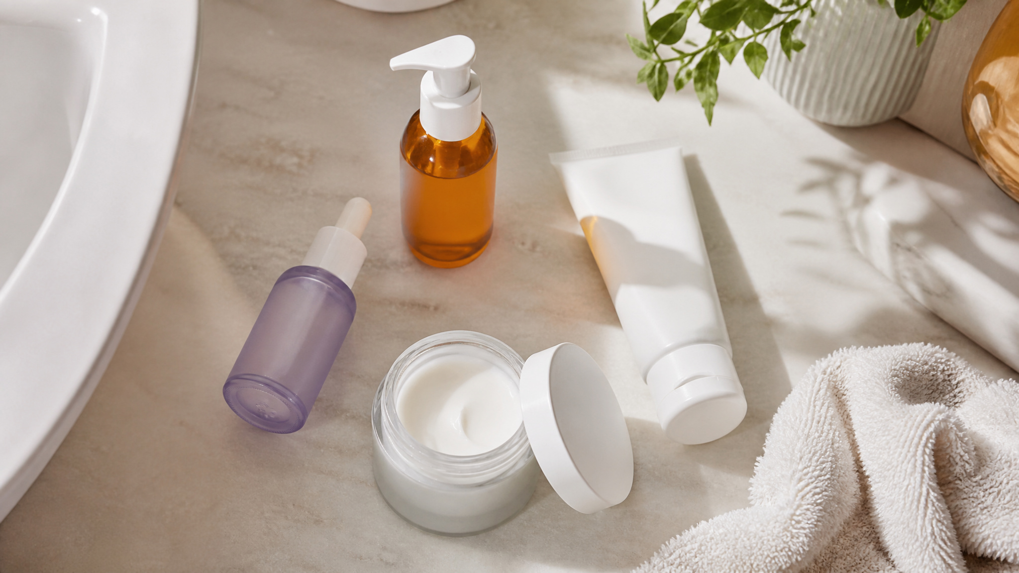 Overhead view of modern drugstore anti-aging skincare products like retinol and vitamin C serum