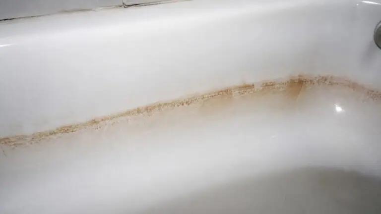 Close-up of a bathtub with brown stains and grime along the surface, indicating the need for thorough cleaning and maintenance.