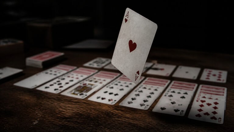 Ace of Hearts card floating above a table with various playing cards laid out, capturing a moment of card game strategy and entertainment.