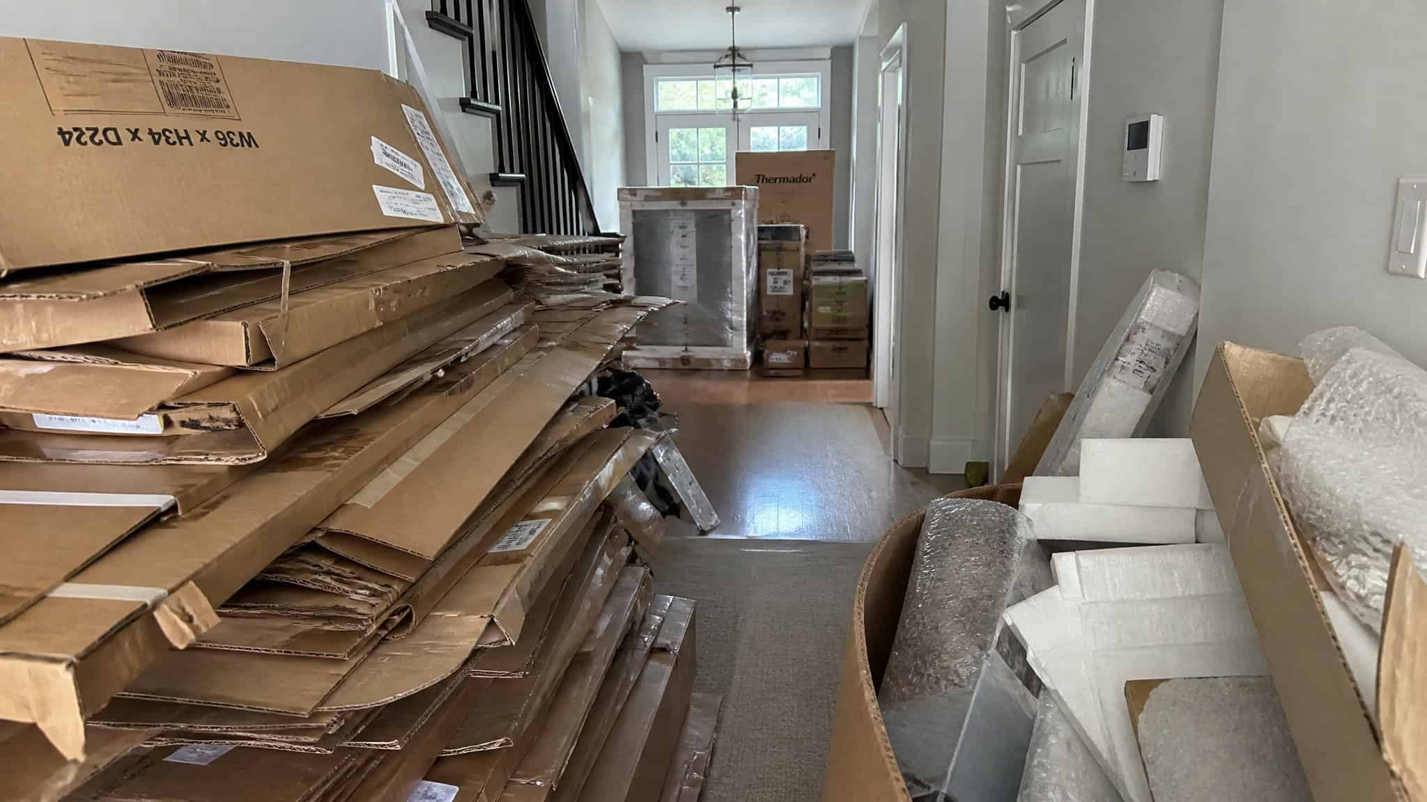 How to Remodel Your Kitchen: 8 Lessons From a Full DIY Remodel 5 Cardboard packaging pile from kitchen remodel shipments staged in a spare room