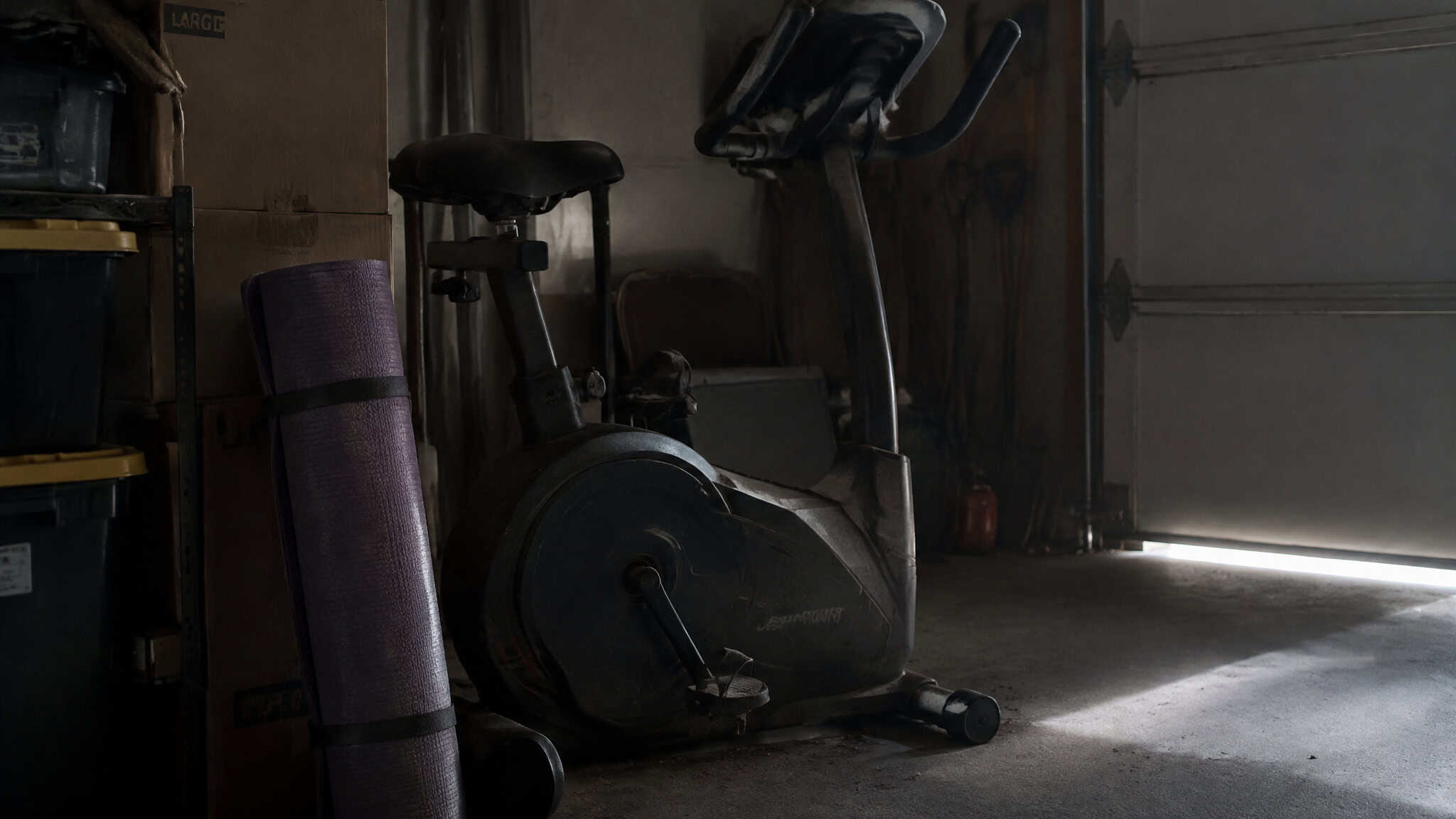 Fitness Trends 2025: What Stuck, What Faded, per the ACSM Survey 4 Unused home gym equipment gathering dust in a garage, illustrating fitness trends that faded in 2025